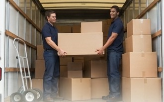 Two movers loading boxes into a moving truck